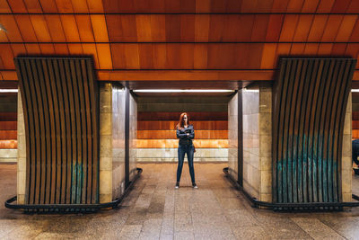 Full length portrait of woman standing in metro