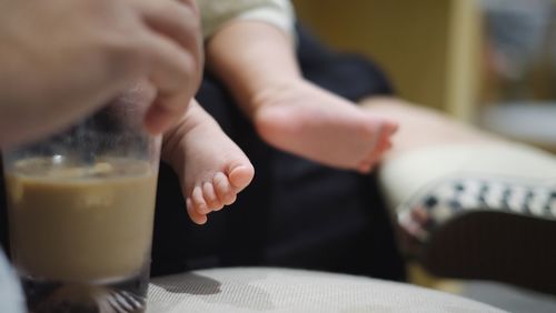 Midsection of man with baby sitting on table