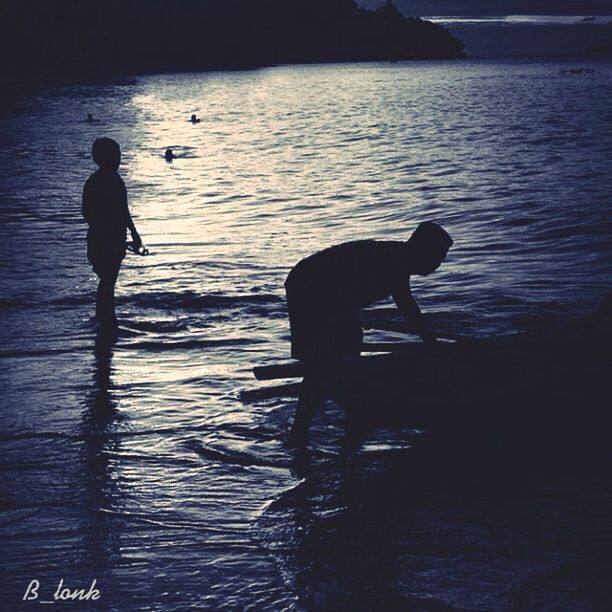 water, silhouette, sea, reflection, beach, full length, sunset, leisure activity, lifestyles, shore, men, togetherness, tranquility, standing, nature, boys, walking, rippled