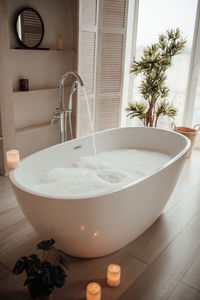 Luxury interior of big bathroom at modern african style with oval bathtub in natural lighting