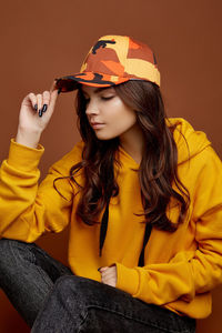 Beautiful young woman sitting with yellow hat