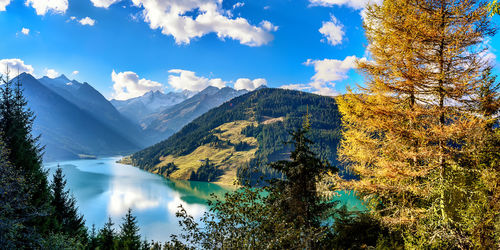 Scenic view of lake by mountains against sky