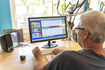 Senior man working in office, using computer