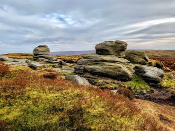 Rocks on field against sky