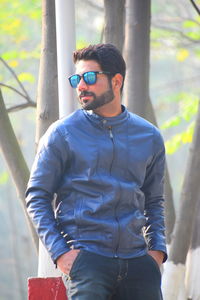 Portrait of young man wearing sunglasses standing outdoors