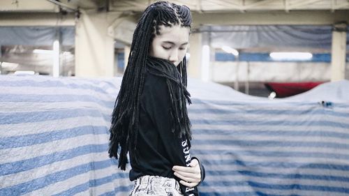 Woman with braided hair standing in basement