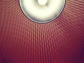 Cropped image of illuminated bulb in lamp shade