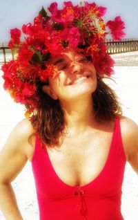 Close-up of beautiful young woman standing at beach against sky