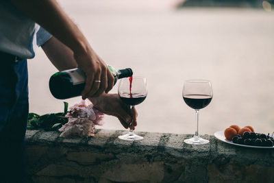 Close-up of hand pouring wine in glass