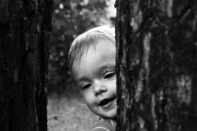 Close-up of cute toddler by tree