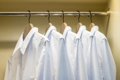 Close-up of white shirts hanging on rack in store