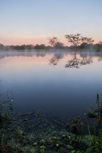 Scenic view of lake against sky at sunset