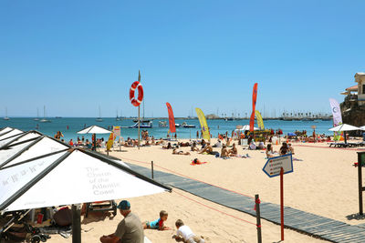 People on beach against clear sky