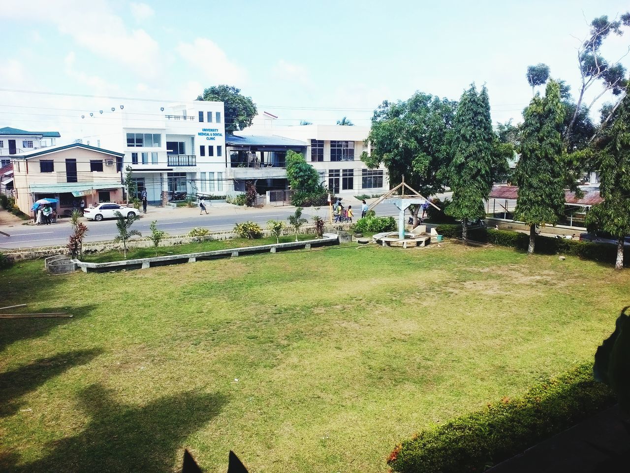 building exterior, architecture, built structure, grass, tree, sky, house, residential structure, residential building, green color, lawn, incidental people, city, sunlight, growth, day, outdoors, plant, shadow, field