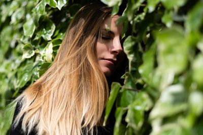 Close-up of young woman by plants