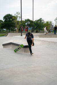 Rear view of man skateboarding on street