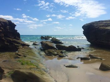 Scenic view of rocks on beach against sky