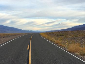 Road by landscape against sky