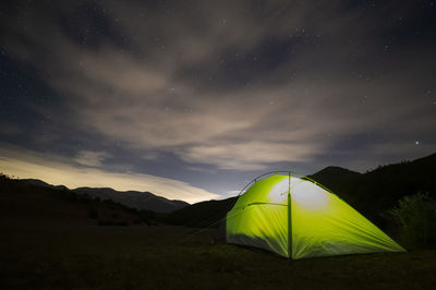 Tent on field against sky at night