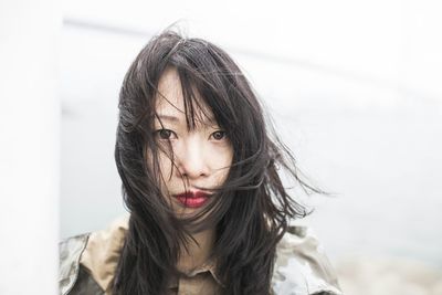 Close-up portrait of woman with hair blowing in wind