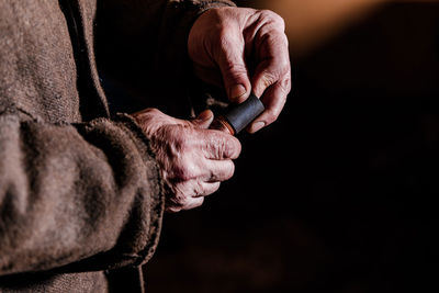 Midsection of man holding remote control