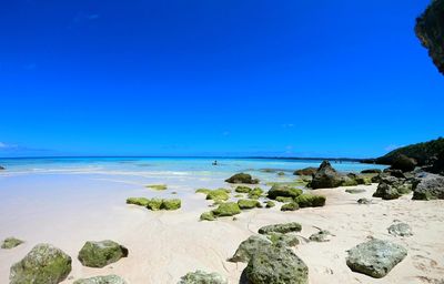 Scenic view of beach against clear blue sky