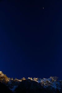 Scenic view of moon against clear blue sky at night