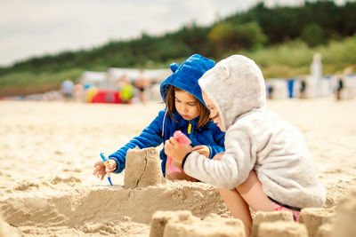 Sisters making sandcastle at beach