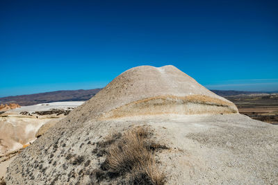 Scenic view of desert against clear blue sky