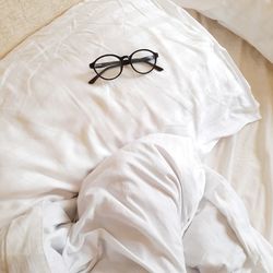 High angle view of eyeglasses on bed at home