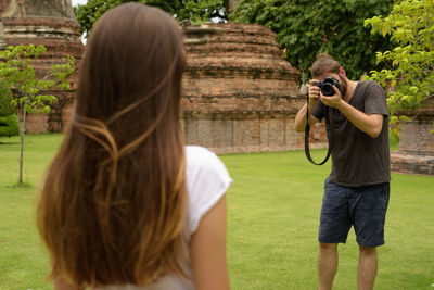 Rear view of woman photographing outdoors