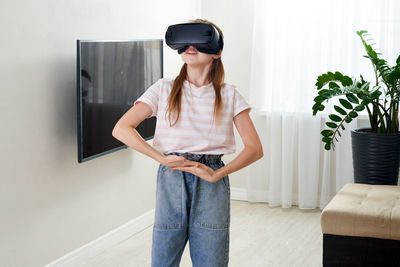 Girl wearing virtual reality simulator at home