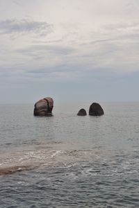 Scenic view of rocks in sea against sky