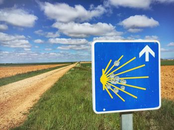 Road on field against cloudy sky