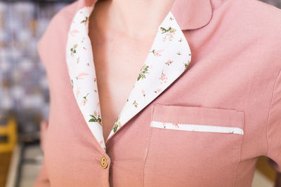 Midsection of woman standing on pink umbrella