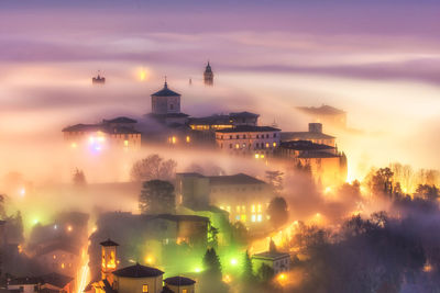 Illuminated city against sky at night