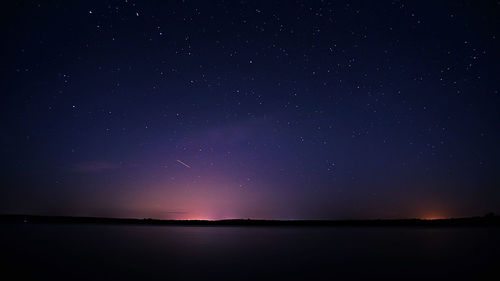 Scenic view of sea against star field at night