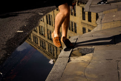 Low section of man in puddle on street