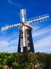 Low angle view of traditional windmill against blue sky