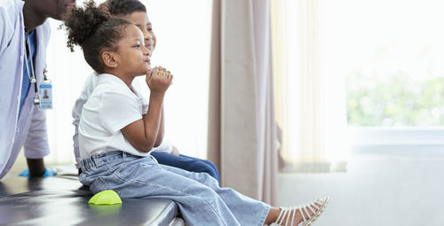 Side view of mother and daughter at home