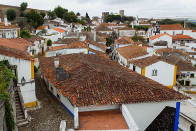 High angle view of houses in medieval town of obidos with castle against sky