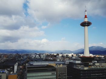 View of cityscape against cloudy sky