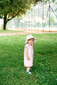 Full length of cute girl wearing hat on field
