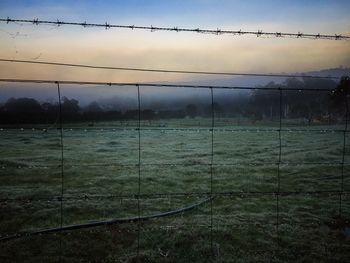 Barbed wire fence on field