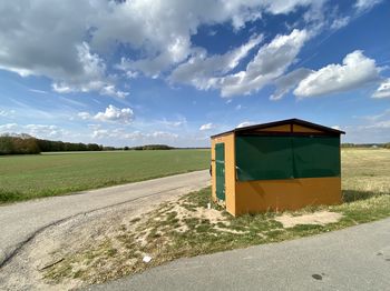 Road amidst field against sky