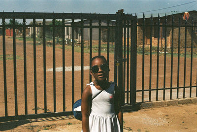 Portrait of man standing by fence