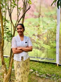 Portrait of smiling woman standing against plants