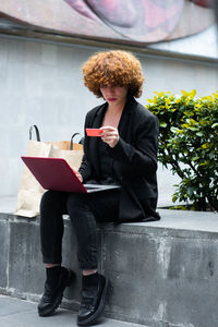 Low angle view of young woman using mobile phone