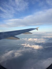 Cropped image of airplane flying over clouds in sky