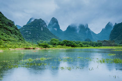 Scenic view of lake and mountains against sky